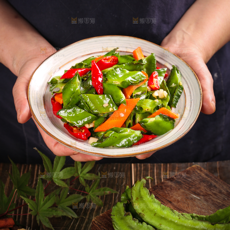 手里拿着一盘炒四角豆