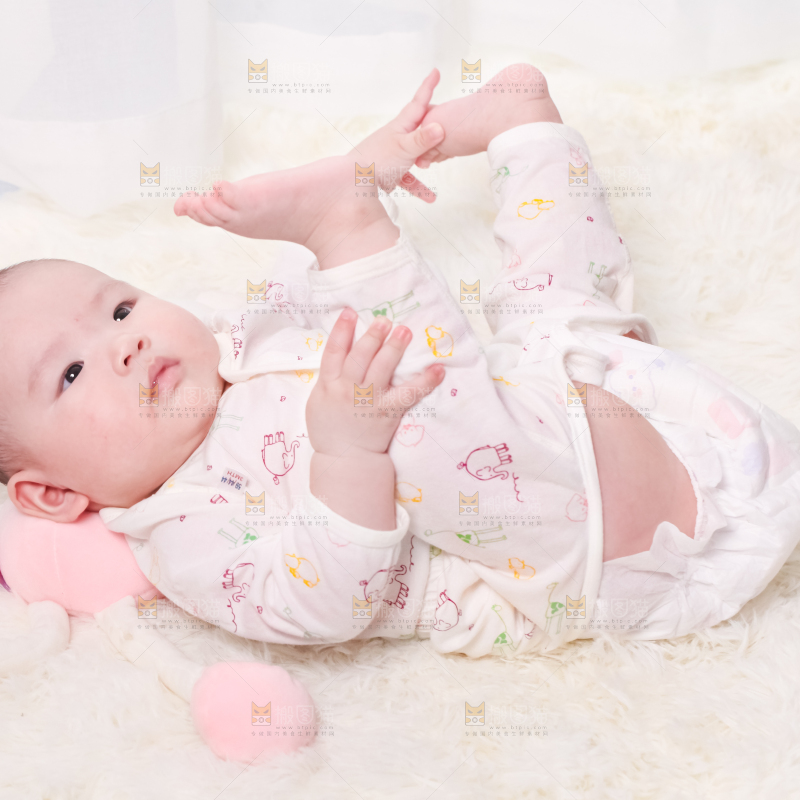 毛毯上躺着一名婴儿