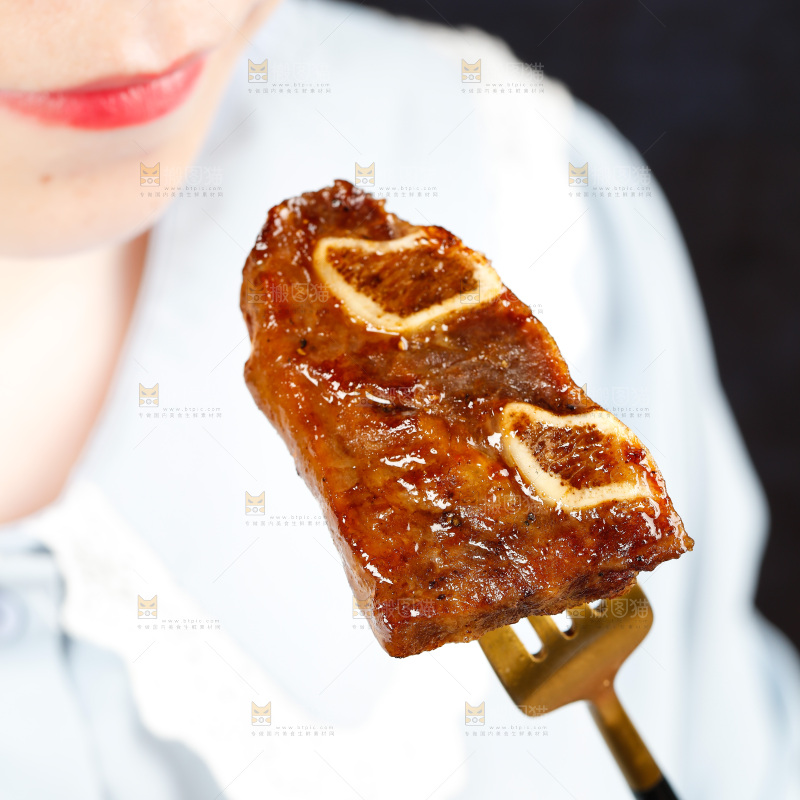 叉子叉着一块煎牛肋骨