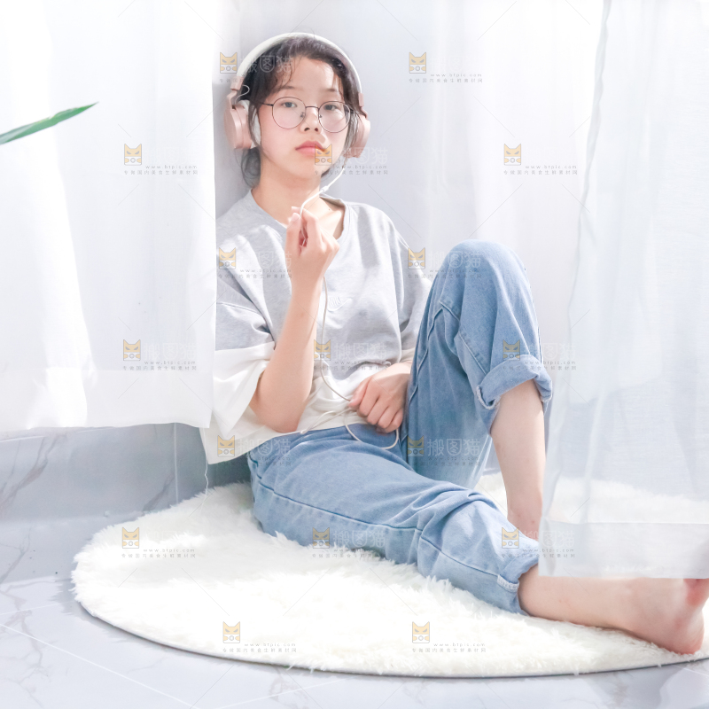 毛毯上坐着一位带耳机的女孩