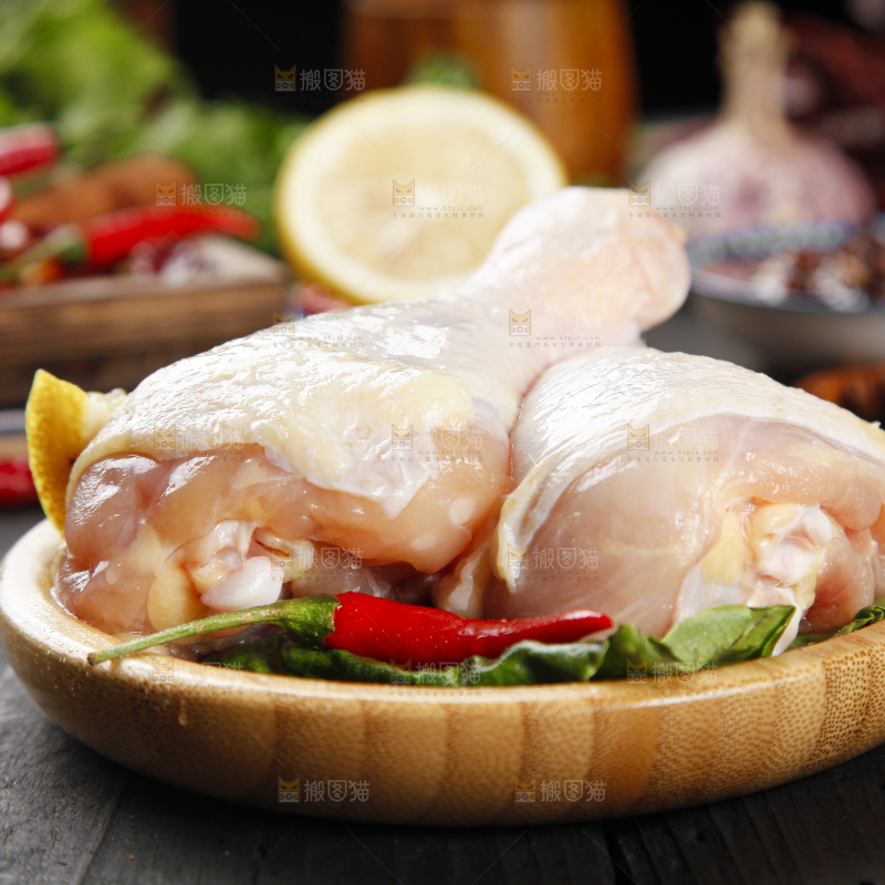 木板上放着一盘新鲜鸡腿