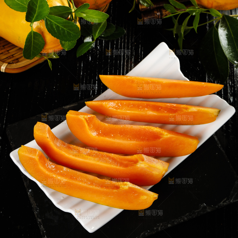 黑底上放着新鲜的海南红心木瓜