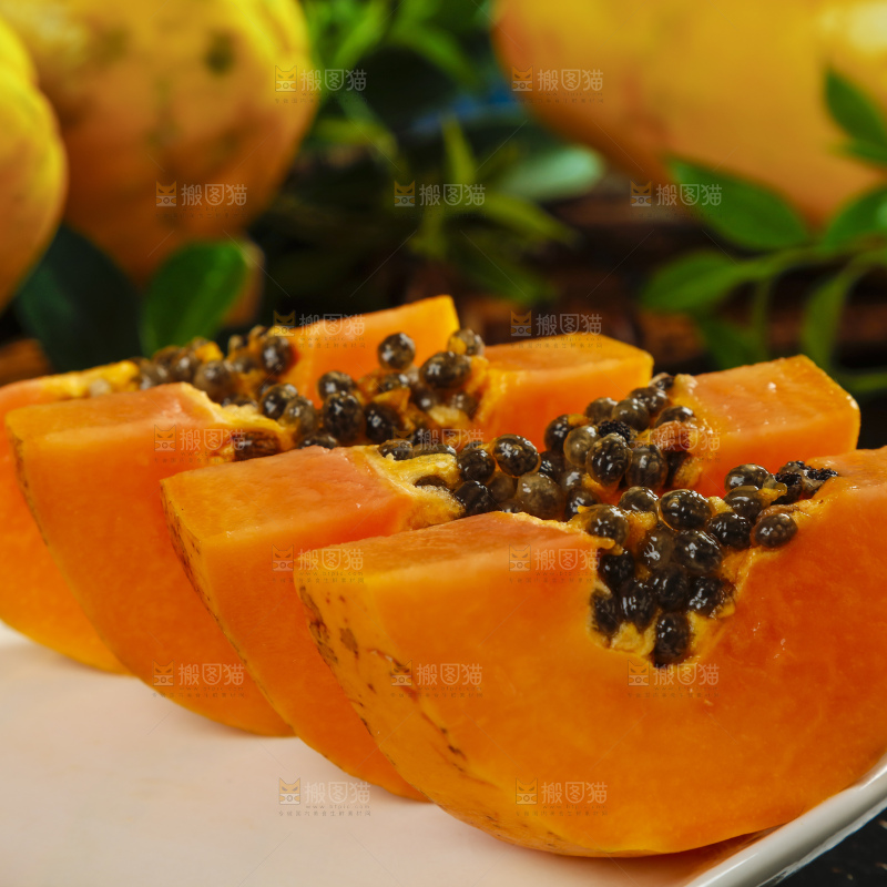 黑底上放着新鲜的海南红心木瓜