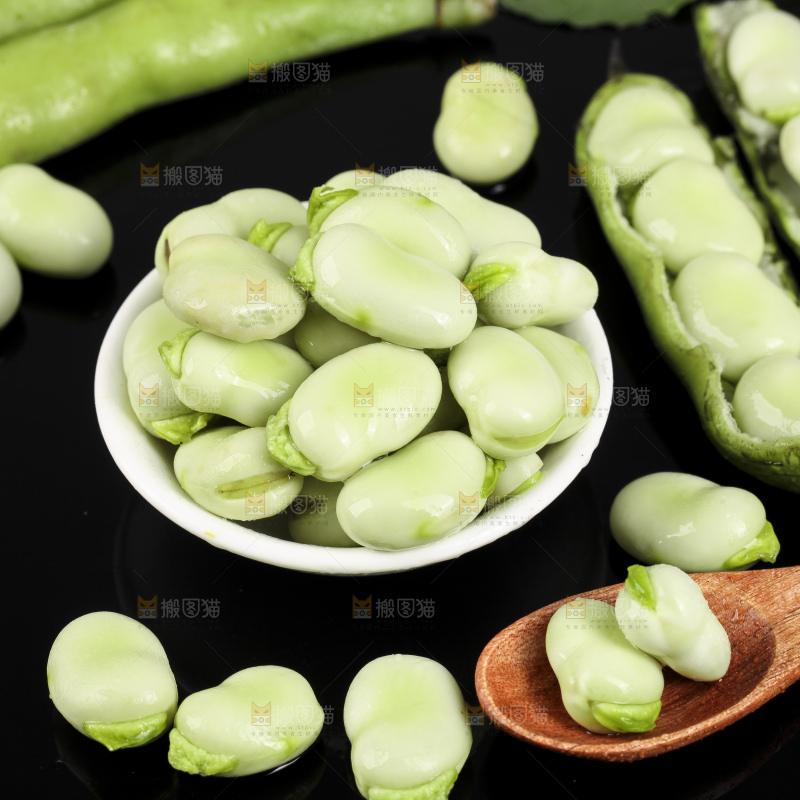 一碗新鲜蚕豆粒放在黑底上