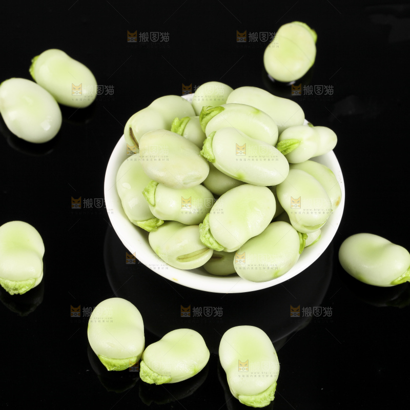 一碗新鲜蚕豆粒放在黑底上