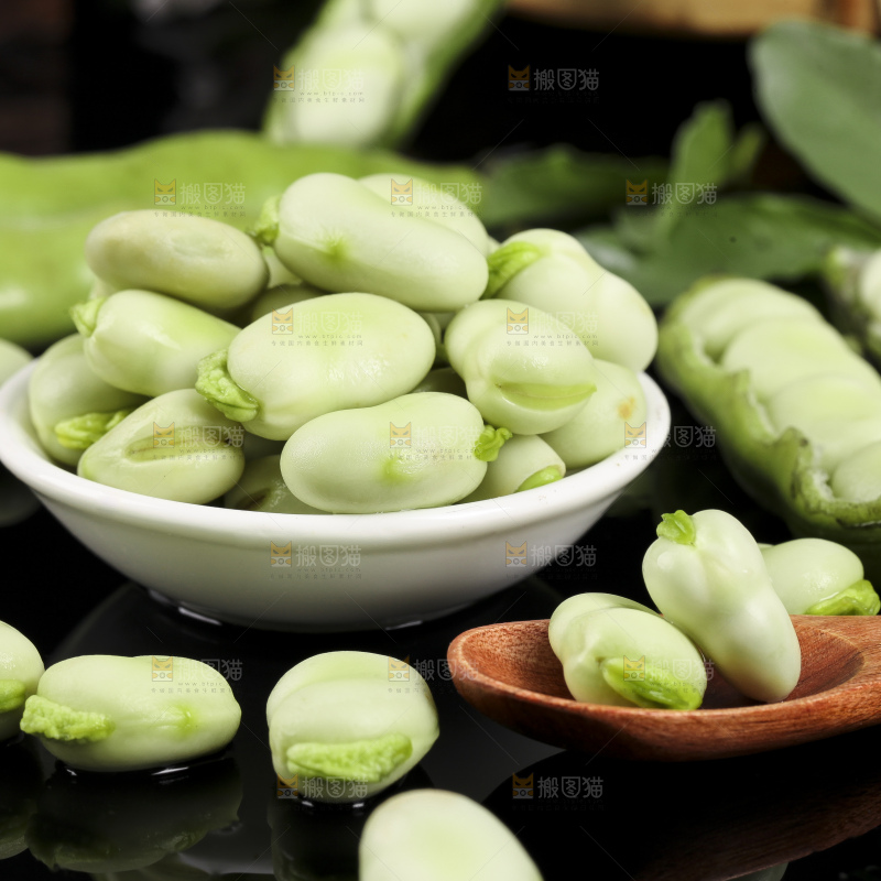 一碗新鲜蚕豆粒放在黑底上