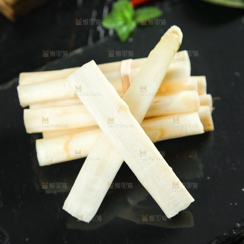 黑石板上放着切开的白芦笋