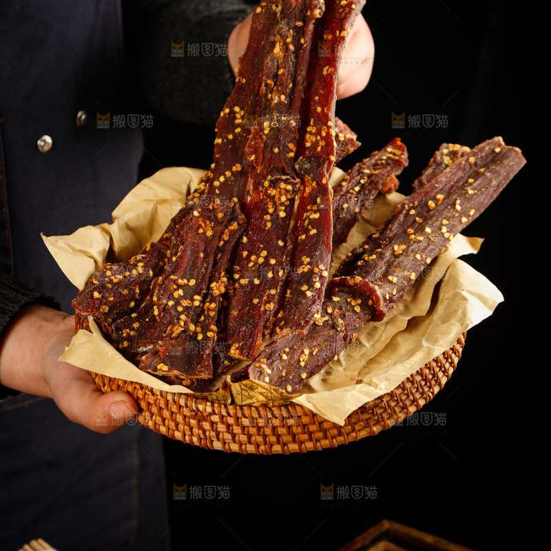 手里端着风干牦牛肉干