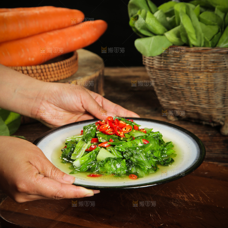 手里端着一盘清炒小白菜