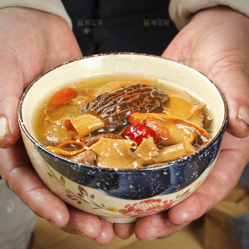 手里端着一碗七彩菌菇炖鸡汤