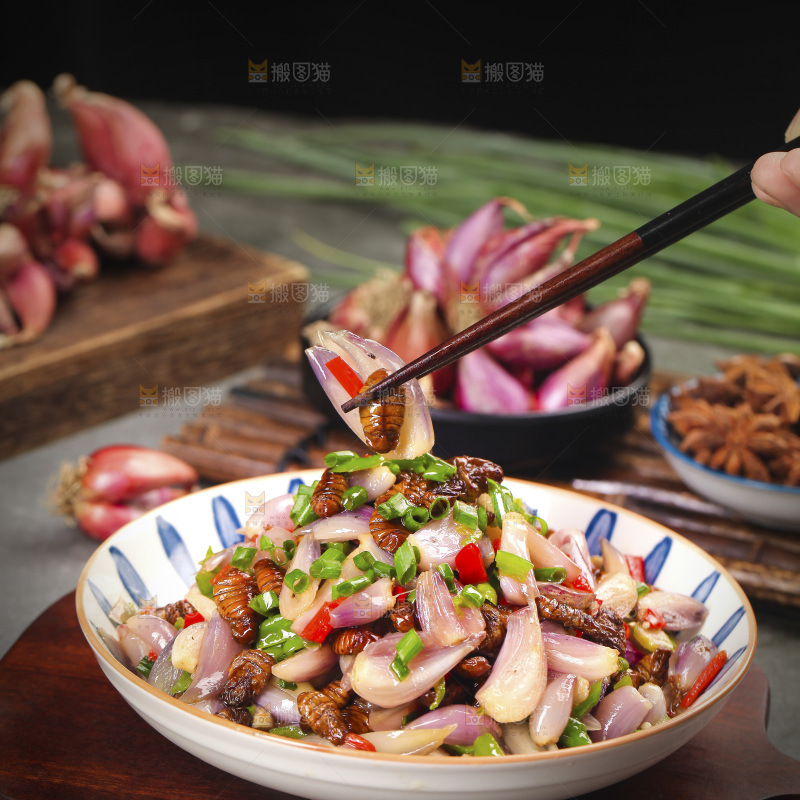 筷子上夹着葱头炒蚕蛹