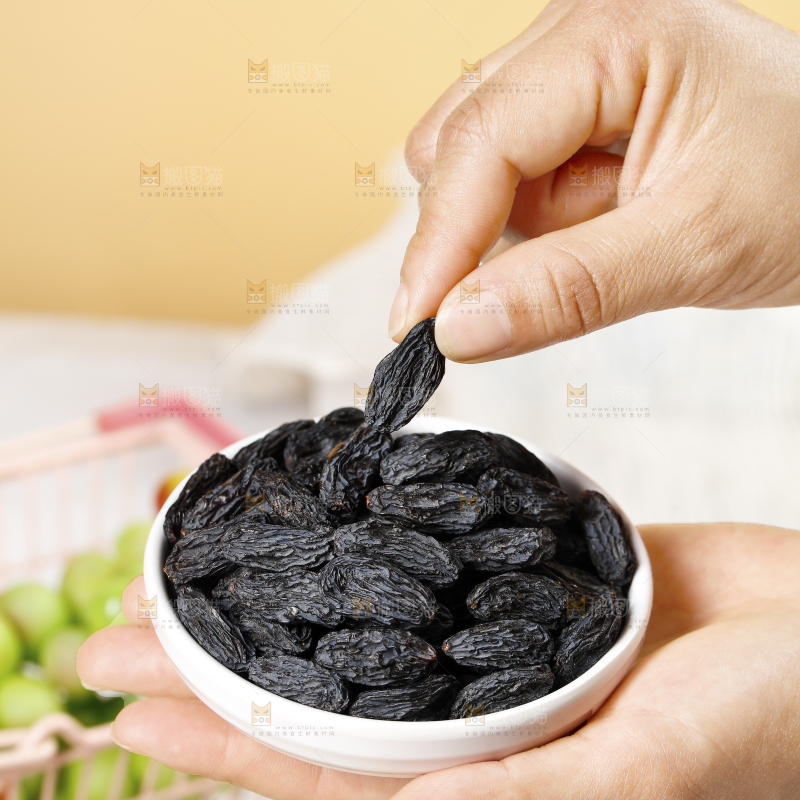 手里端着一盘黑加仑葡萄干
