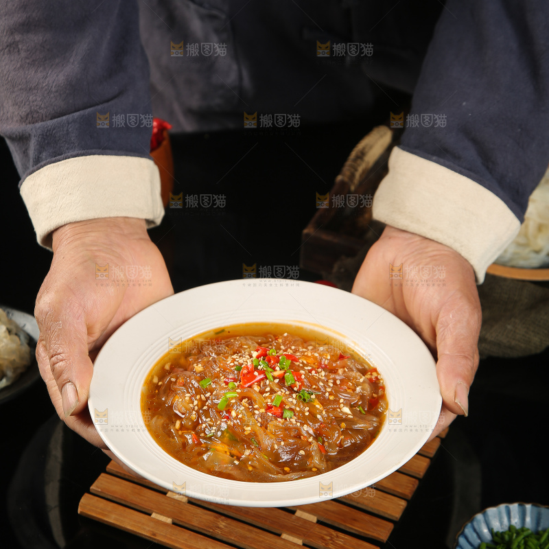 手里端着一盘酸辣海蜇丝