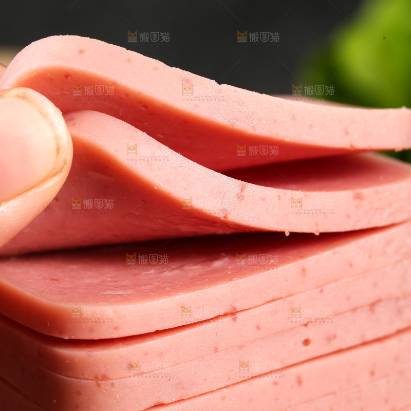 手里拿着切片的午餐肉
