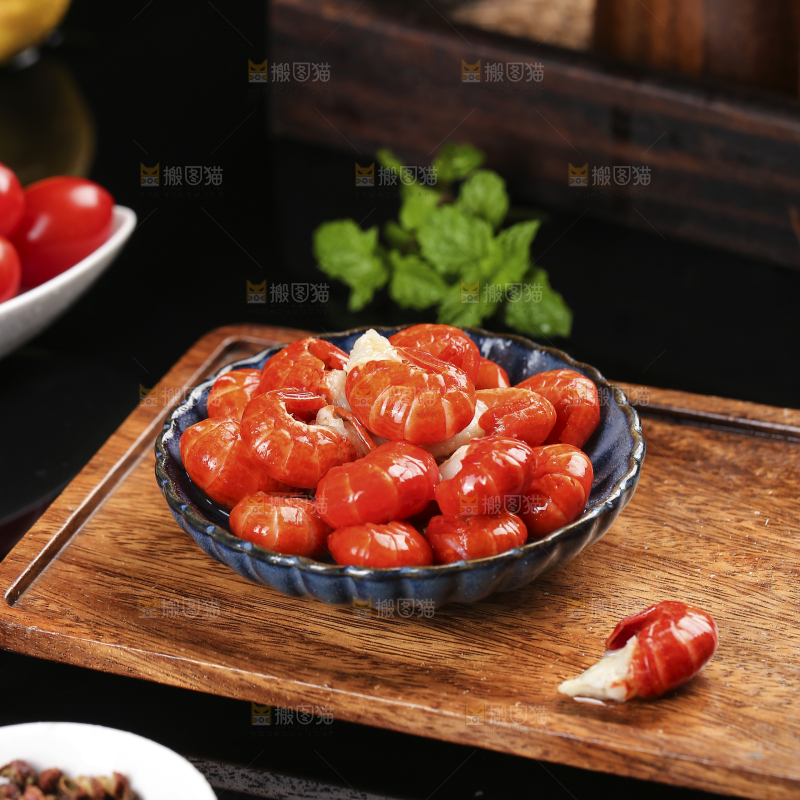 木板上放着一盘龙虾尾