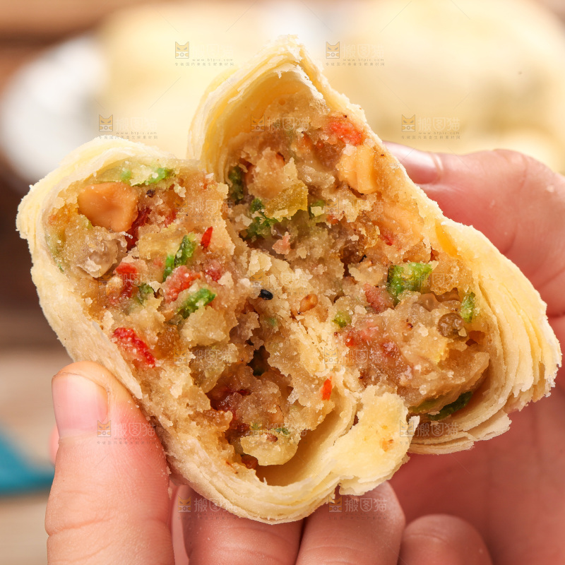 手拿着掰开的酥皮月饼