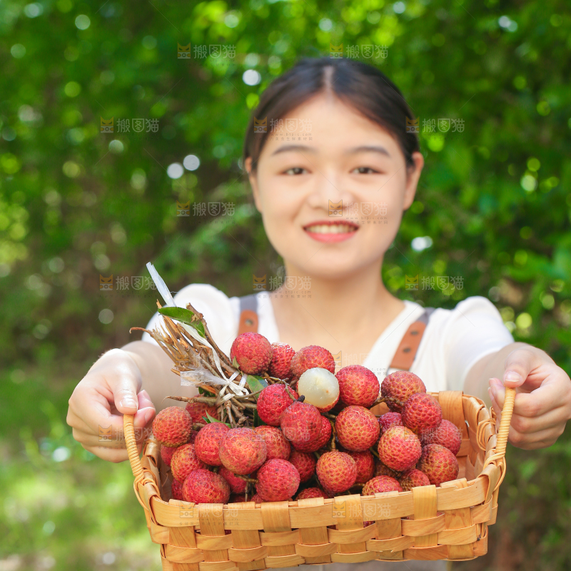 女人手上拿着一筐无核荔枝