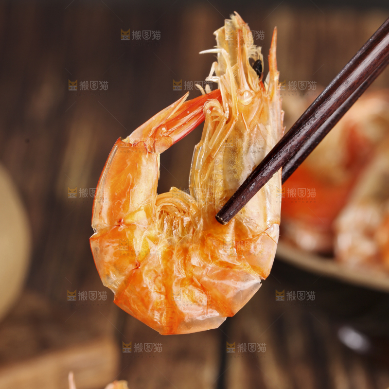 筷子上夹着碳烤虾