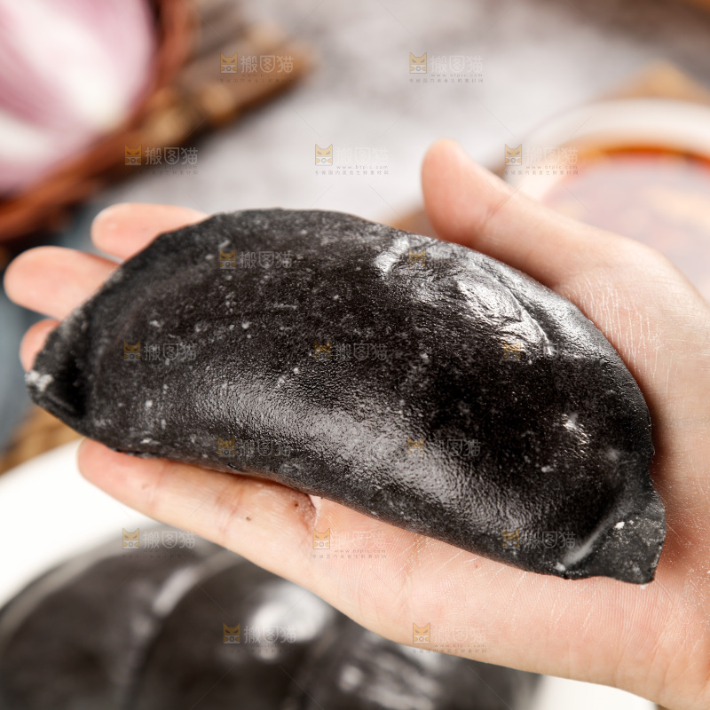 手上放着墨鱼大饺子