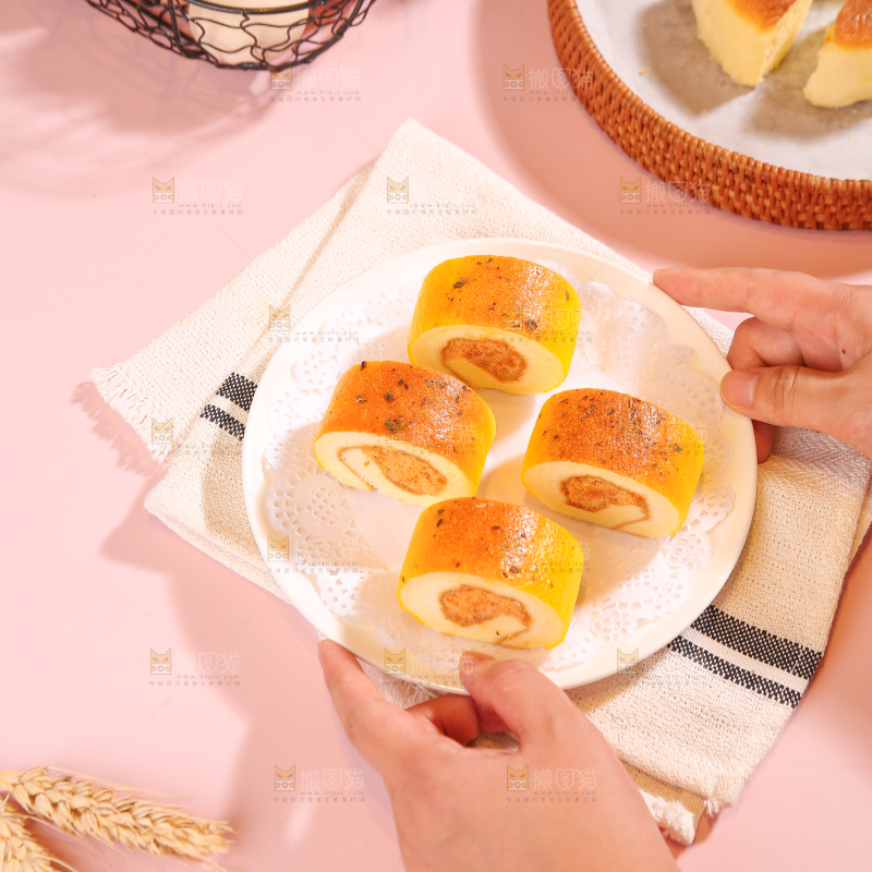 手端着一盘肉松蛋糕卷