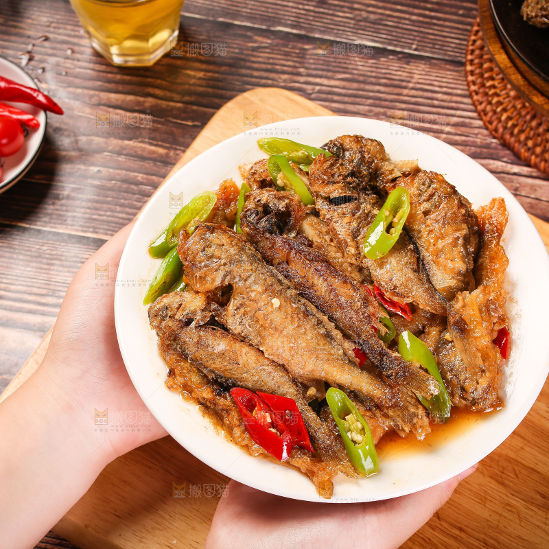 手端着一盘香酥煎鱼