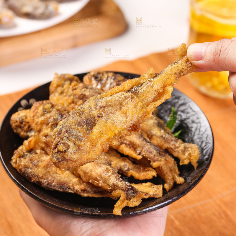 手里拿着香酥炸鱼