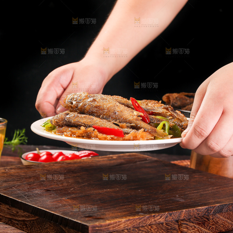 手端着一盘香酥煎鱼