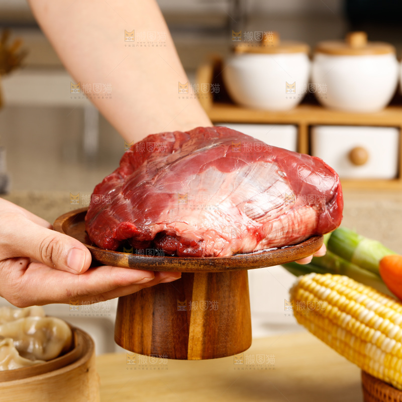 手端着一盘生牛肉