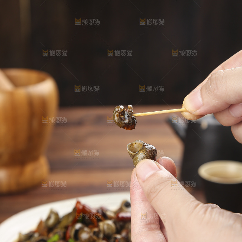 手里拿着牙签挑田螺肉