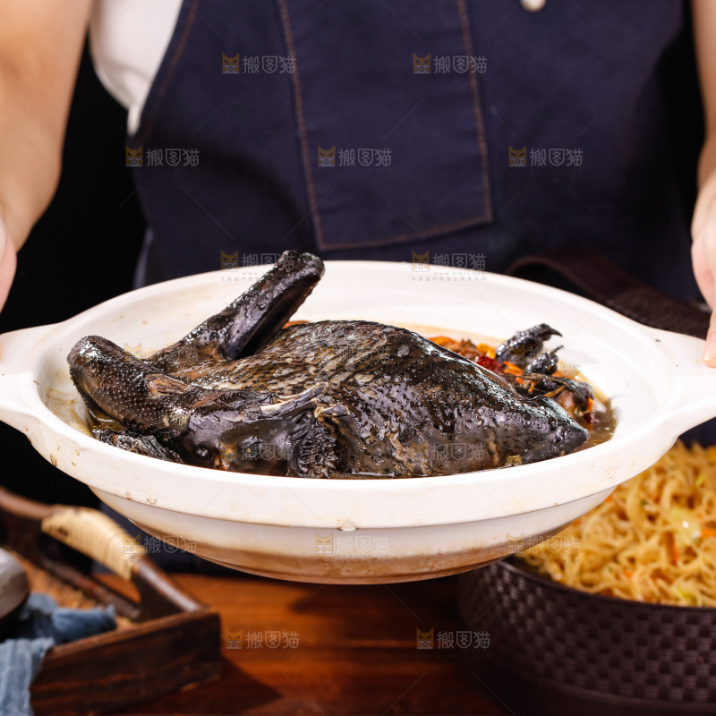 手里端着一锅茶树菇乌鸡汤