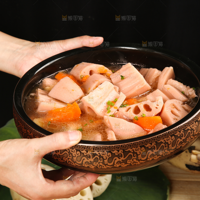 手里端着一碗胡萝卜粉藕汤