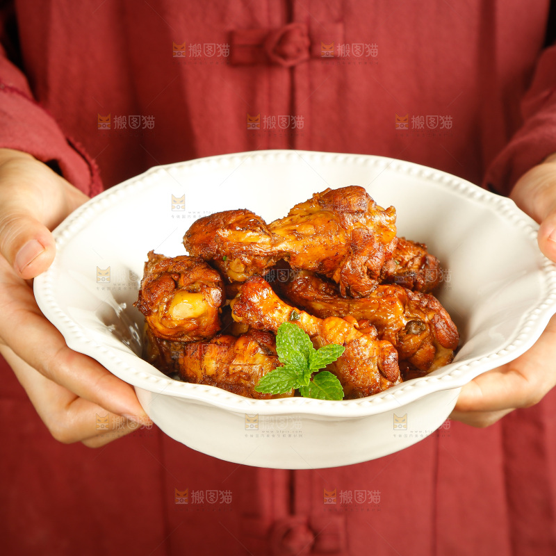 手里端着一盘红烧小鸡腿