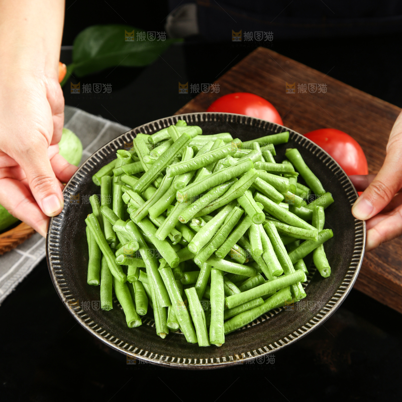 手里端着一盘豇豆