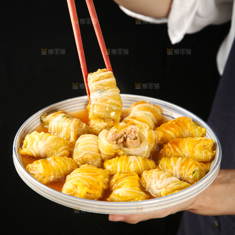 手里端着一盘白菜酿肉卷