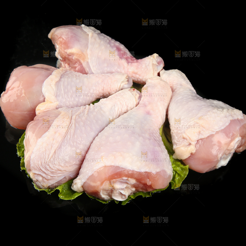 一堆新鲜鸡腿摆放在黑底上