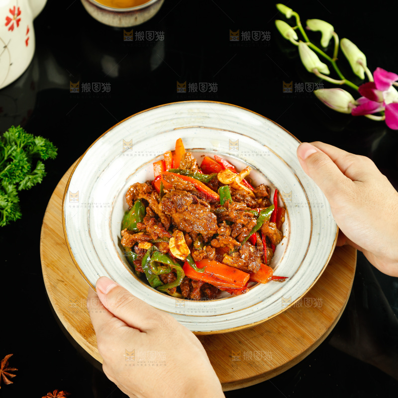 手里端着一盘香辣牛肉