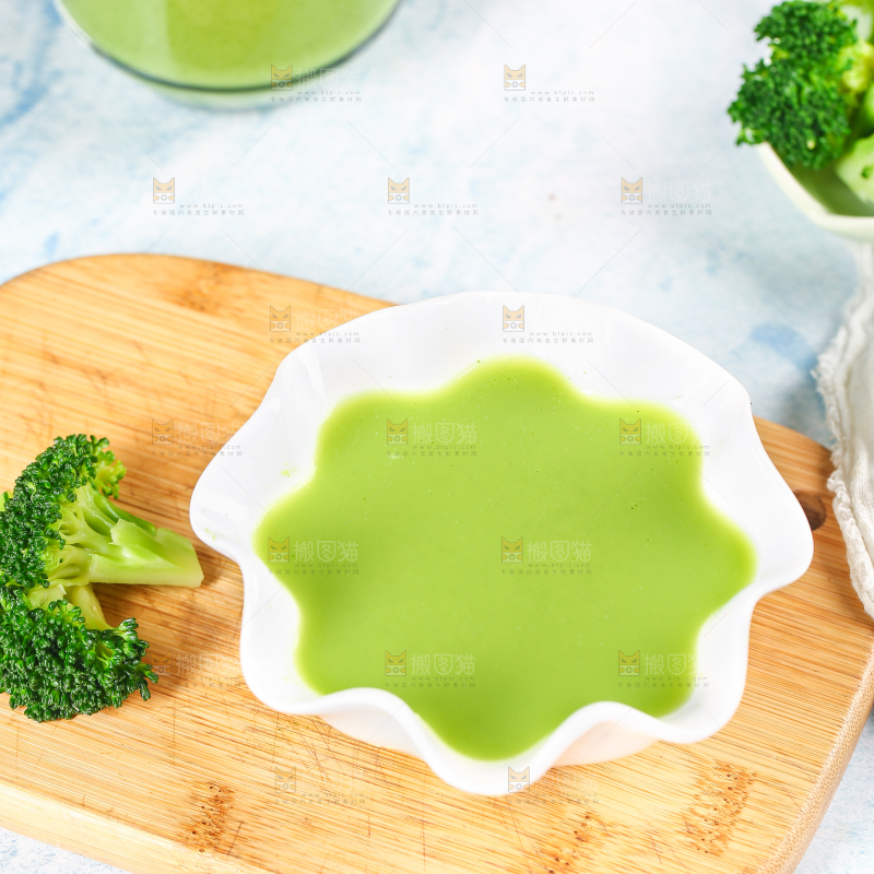 木板上摆放着一碗西兰花泥