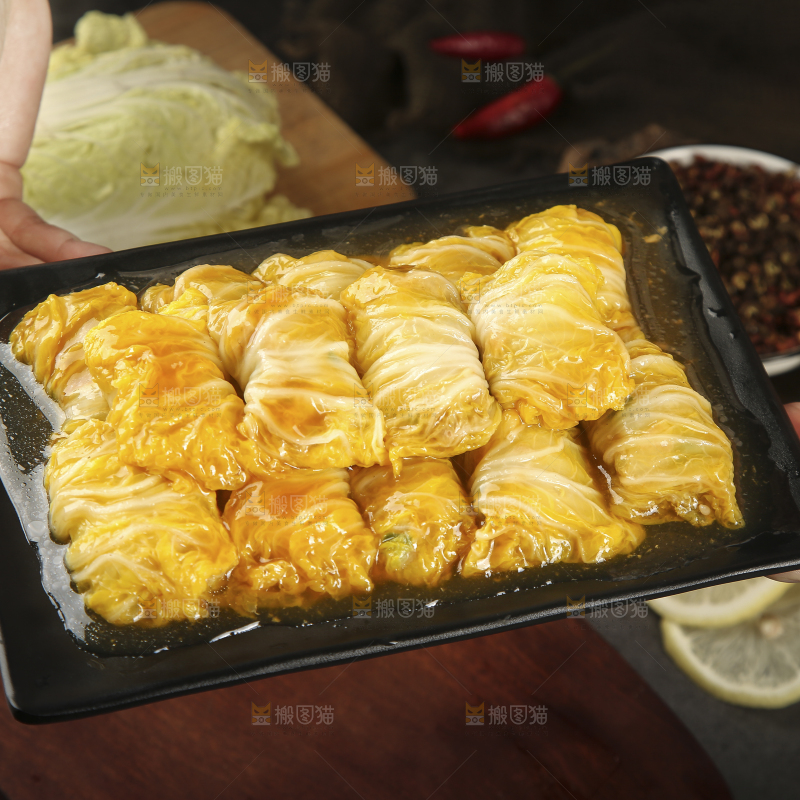 手里端着一盘白菜酿肉卷