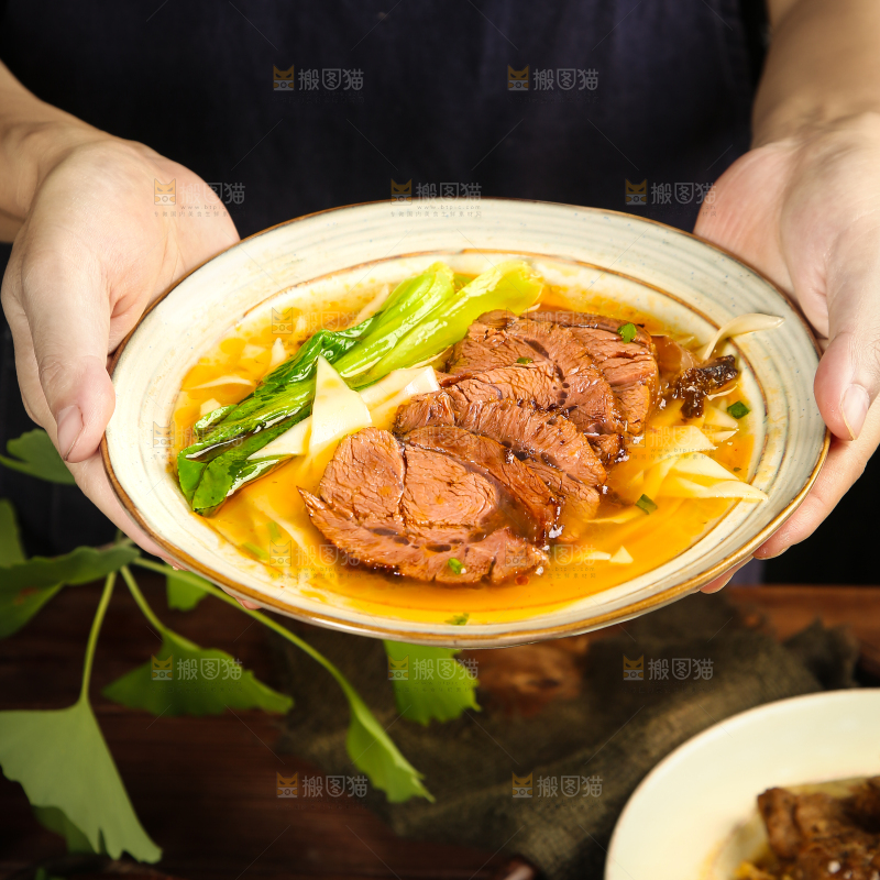手里端着一碗刀削牛肉面