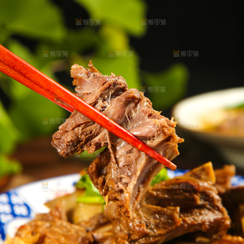 筷子上夹着红烧牛排