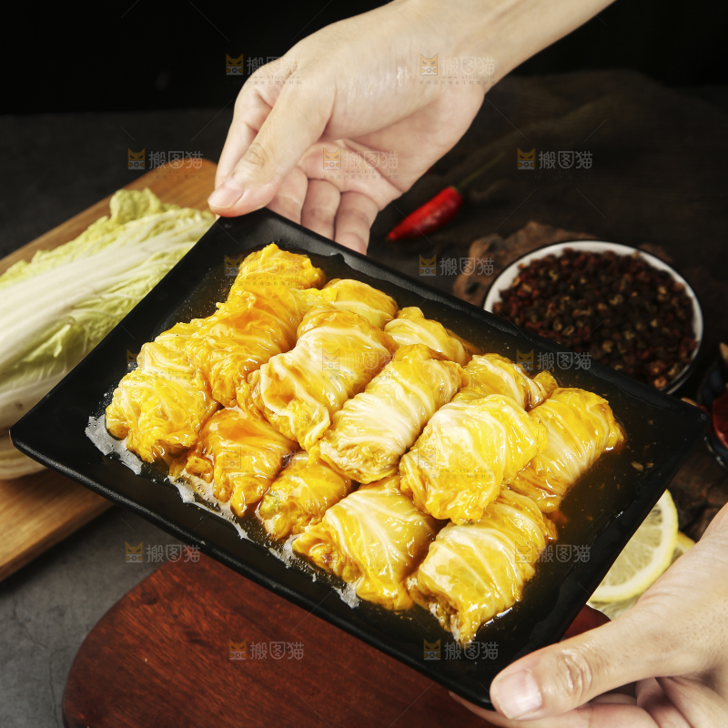 手里端着一盘白菜酿肉卷