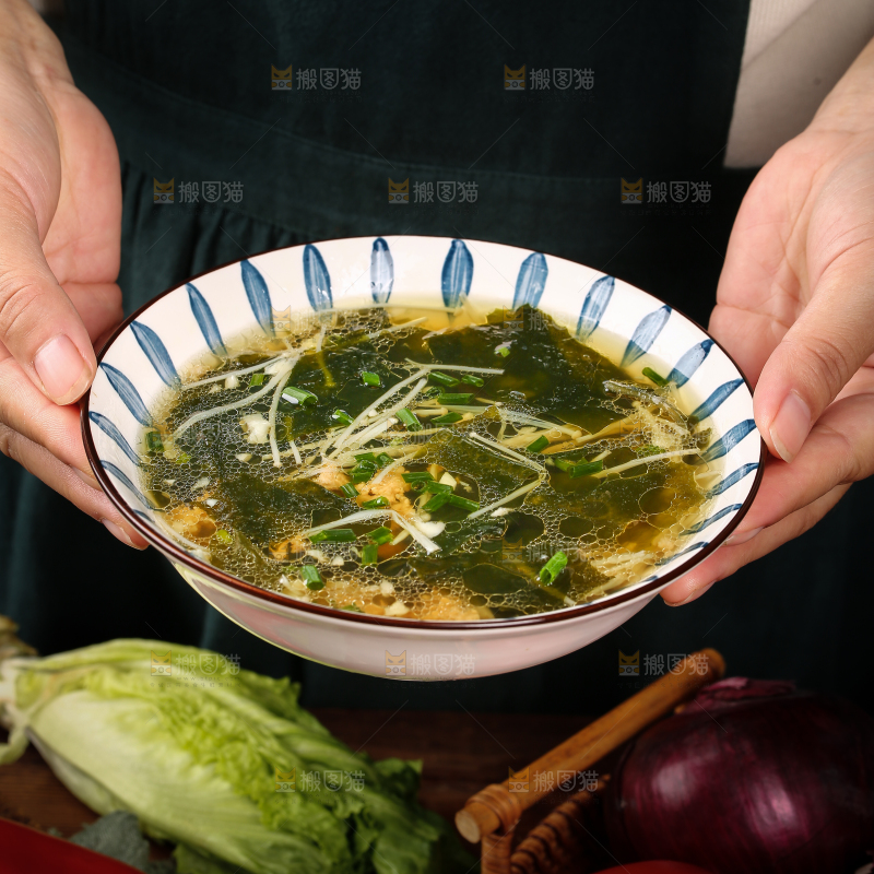 手里端着一盘裙带菜汤