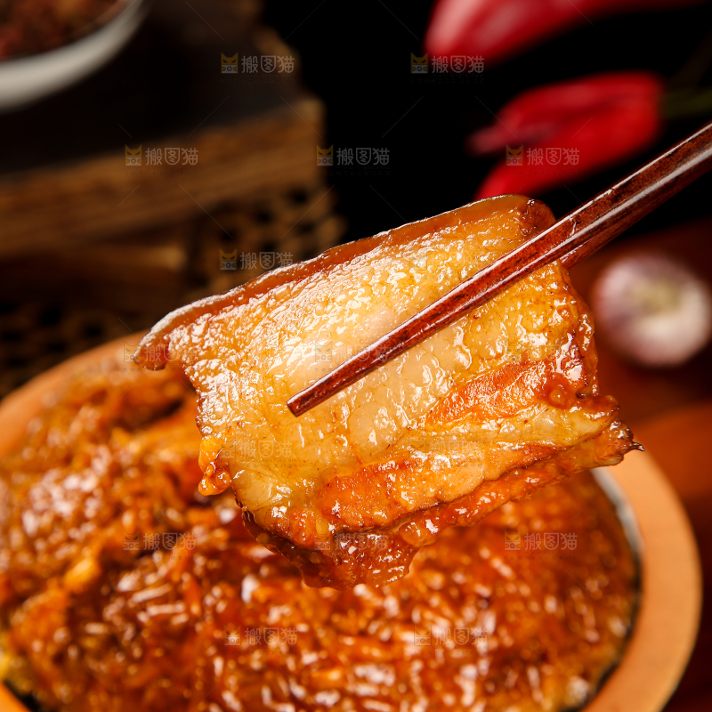一盘烧白扣肉和筷子上夹着肉
