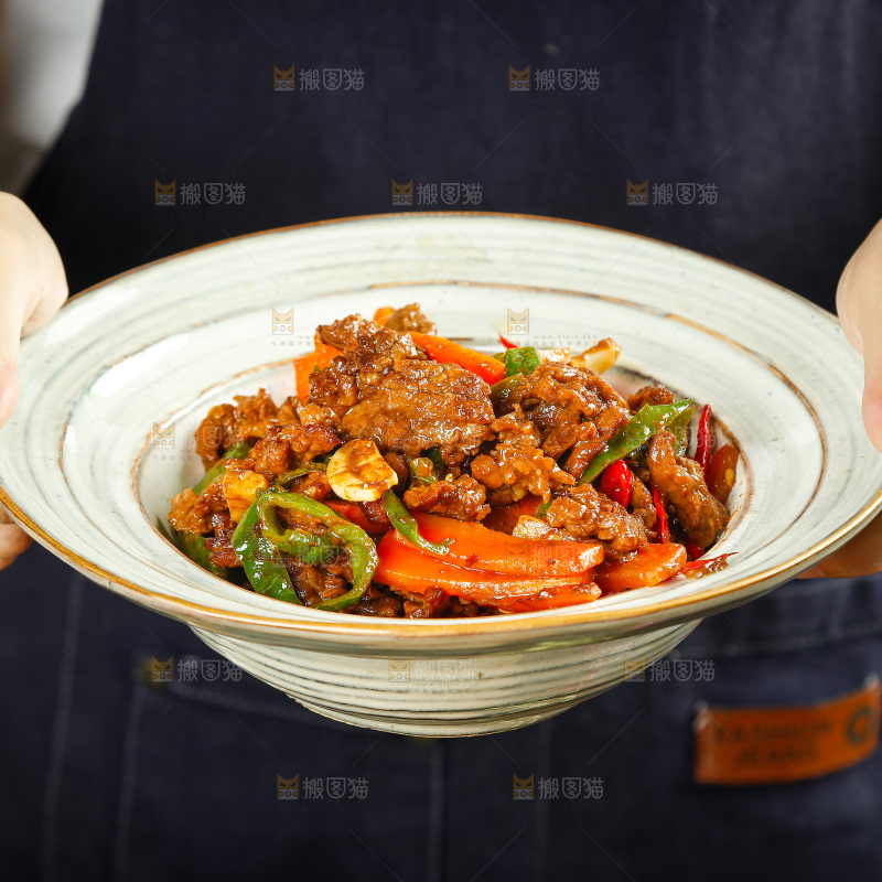 手里端着一盘香辣牛肉