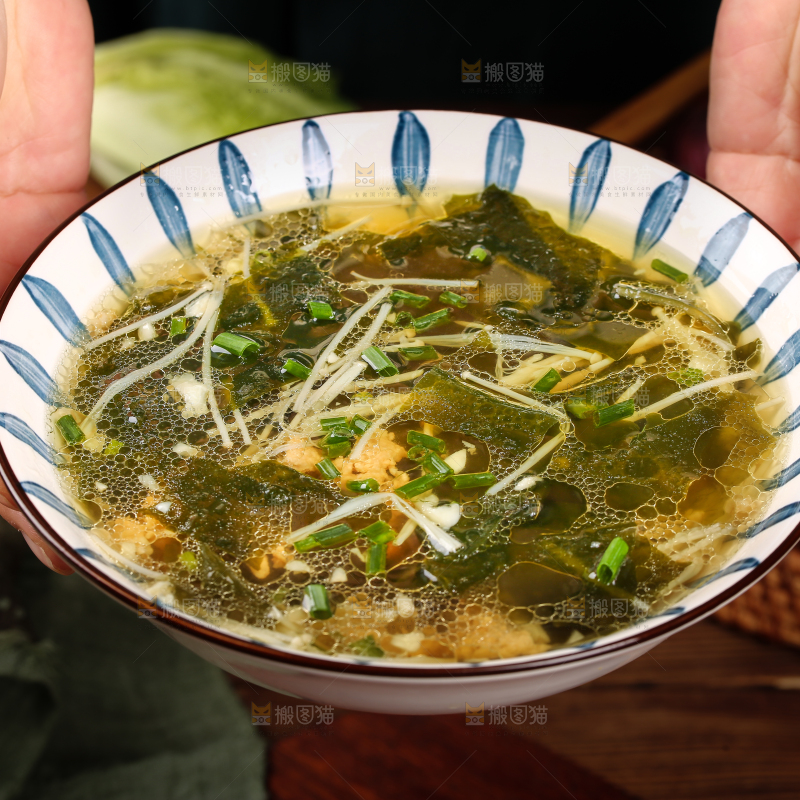 手里端着一盘裙带菜汤