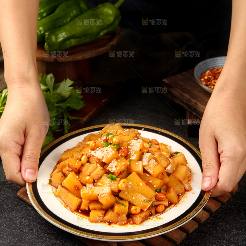 手里端着一盘香辣米豆腐
