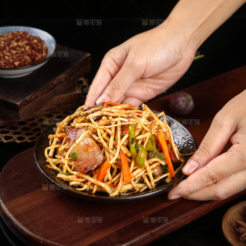 手里端着一盘腊味小炒鱼腥草
