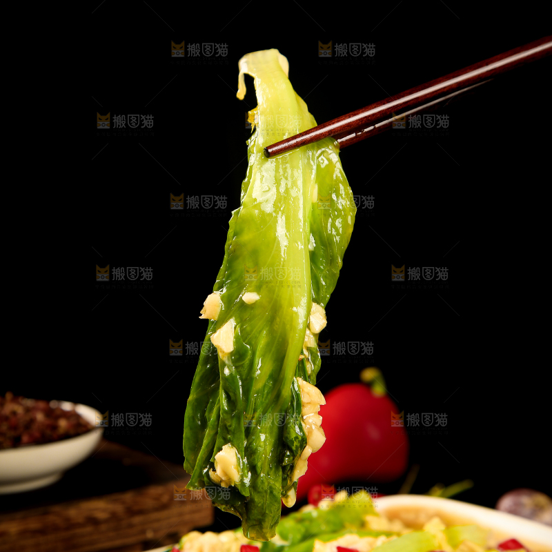 筷子上夹着白灼生菜