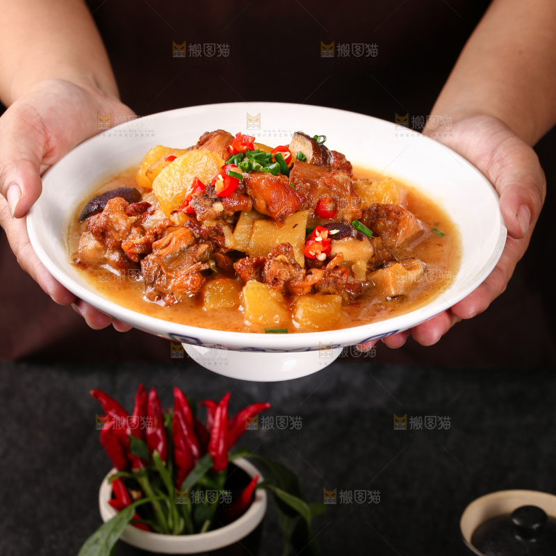手里端着一盘土豆香菇焖鸡