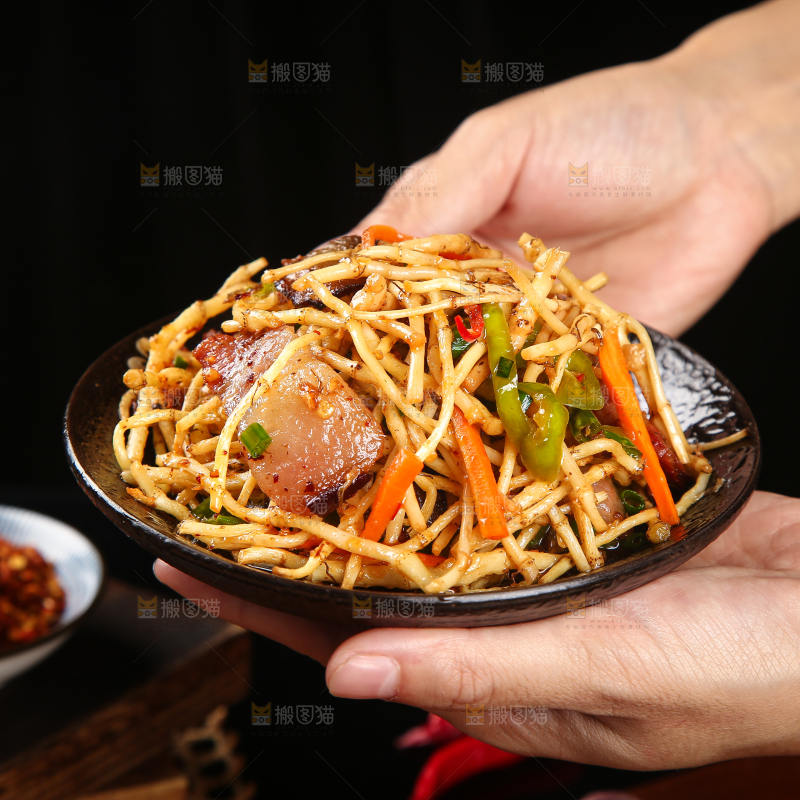 手里端着一盘腊味小炒鱼腥草